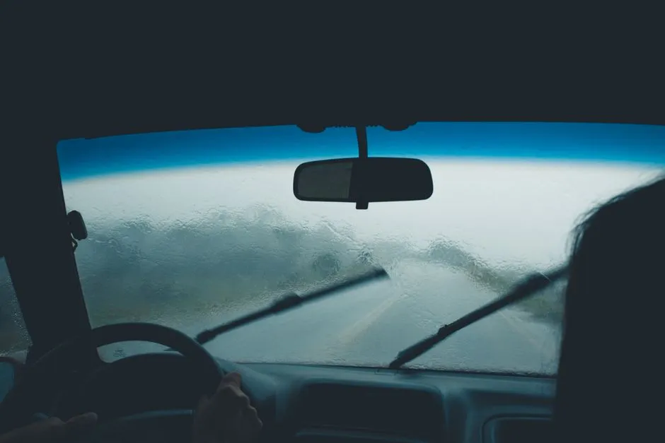 Route mouillée vue depuis le pare-brise sous une pluie fine
