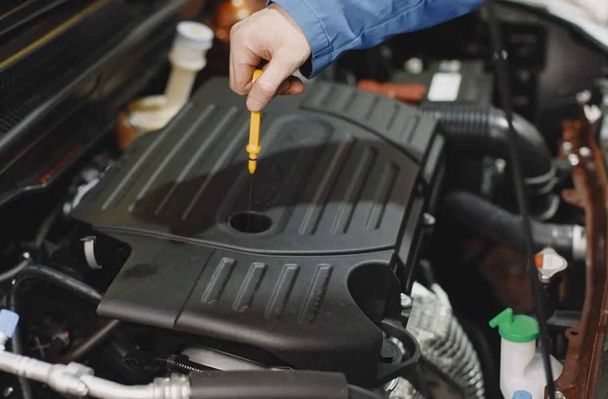 Mains gantées qui contrôlent le niveau de liquide dans un compartiment moteur