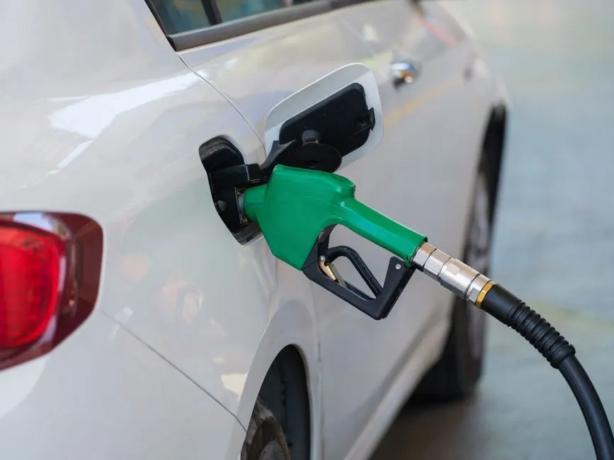 Pistolet de carburant introduit dans la trappe d'une voiture à la station