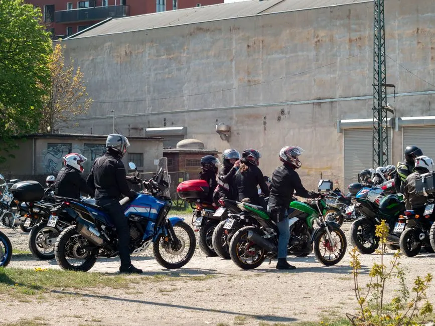 Motard casqué au guidon d'une moto de cylindrée moyenne à l'arrêt