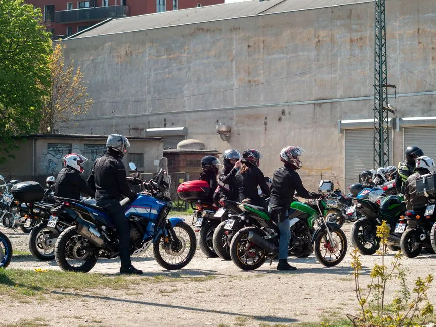 Motard casqué au guidon d'une moto de cylindrée moyenne à l'arrêt