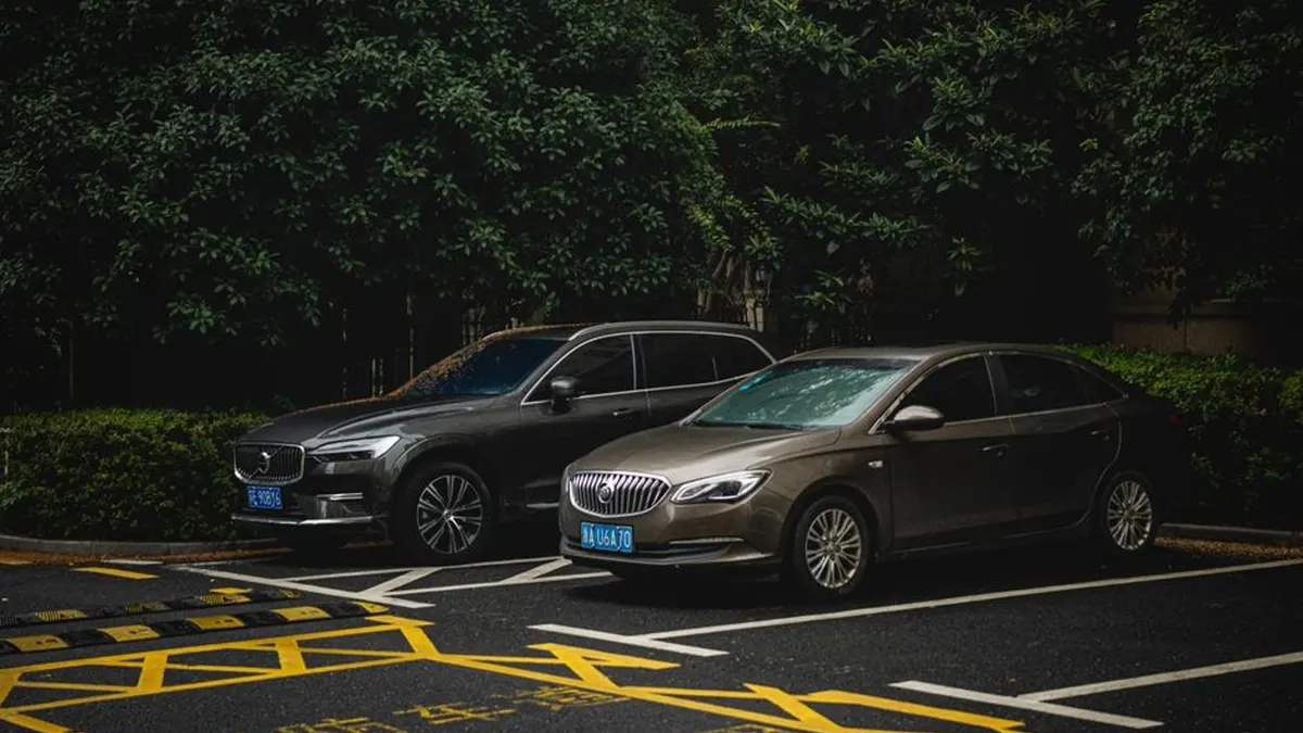Deux voitures stationnées côte à côte sur un parking pour un comparatif