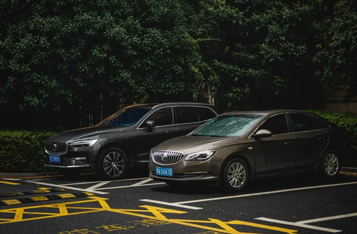 Deux voitures stationnées côte à côte sur un parking pour un comparatif