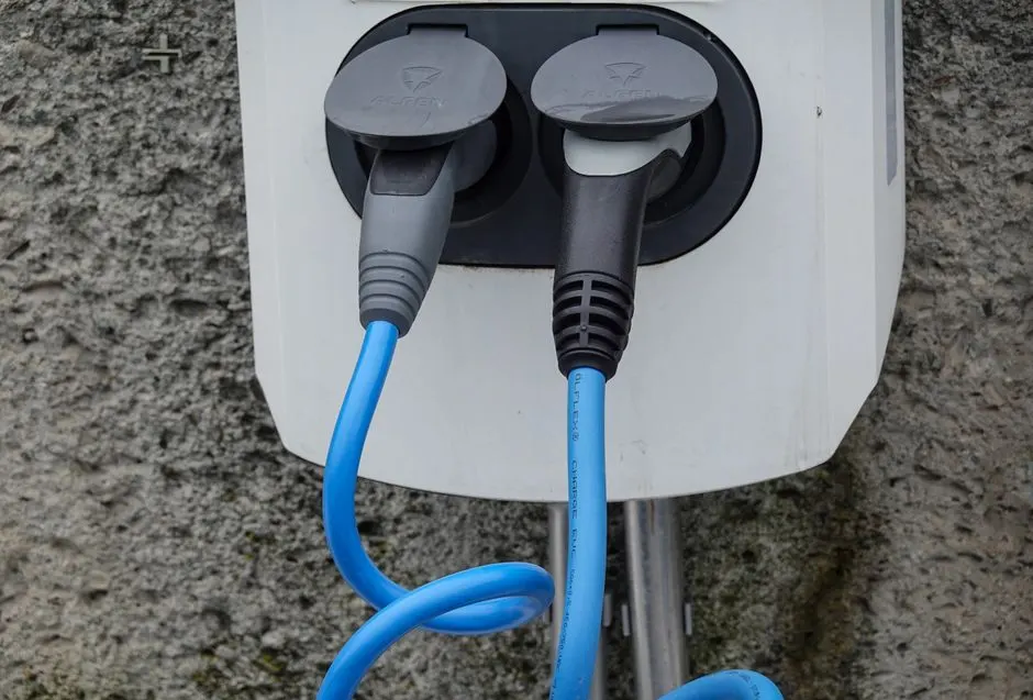 Voiture électrique branchée à une borne de recharge sur un parking