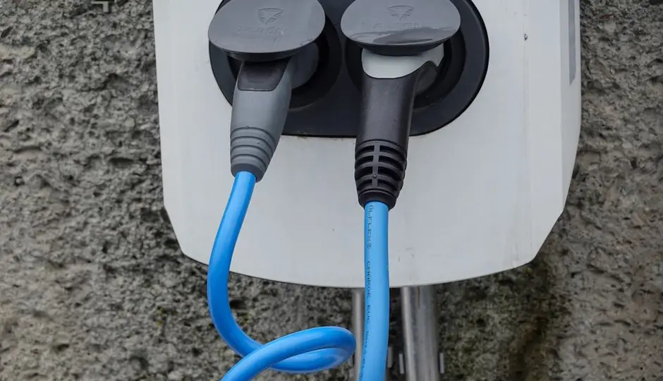 Voiture électrique branchée à une borne de recharge sur un parking
